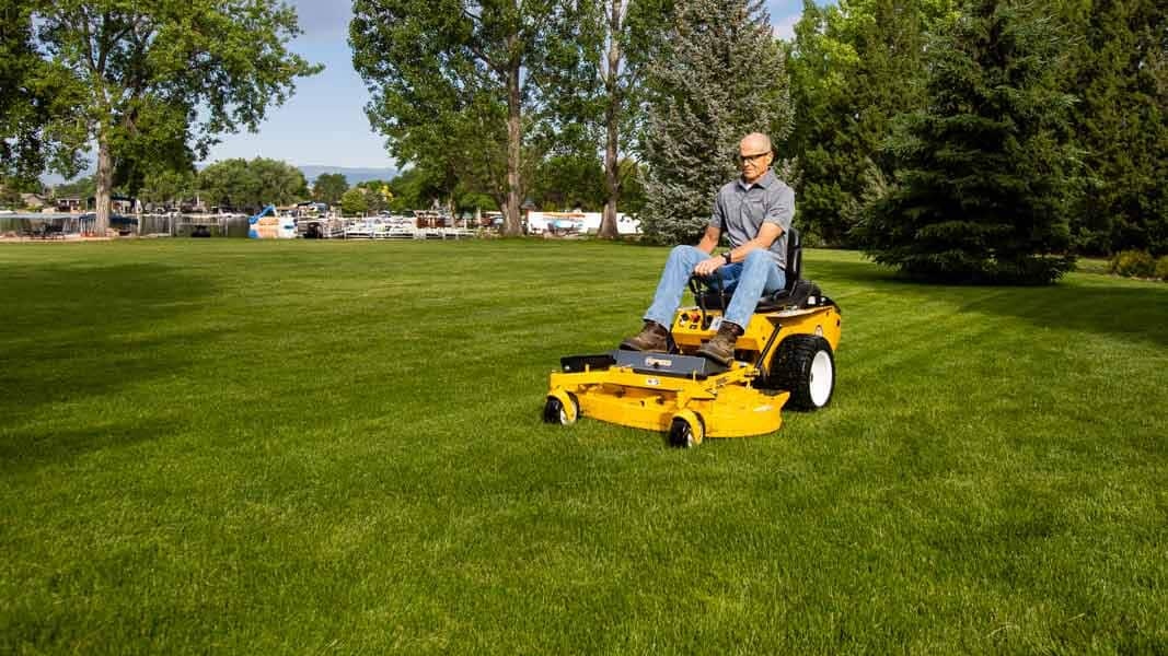 Man mowing a lawn on a Walker Model R lawn mower